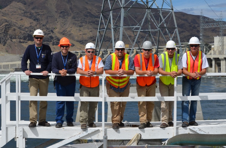 Group of Grant PUD employees standing near dam railing